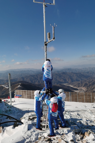 2022年1月25日，延慶賽區駐場的北京冬奧 會冬殘奧會外圍氣象服務團隊現場觀測保障人員 正在維護國家高山滑雪中心競速賽道附近的自動 氣象站。