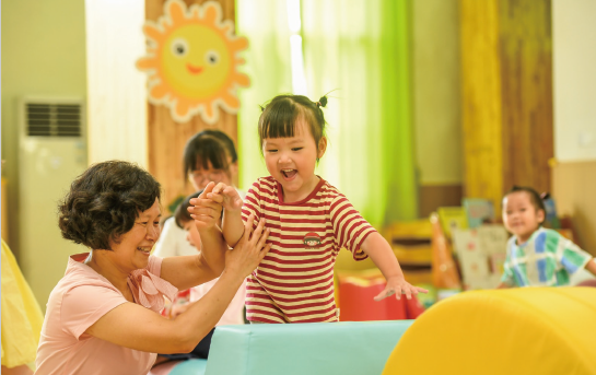 近年來，各地著力解決3歲以下嬰幼兒家庭入托難、入托貴等 問題，大力發展完善普惠托育服務體系，不斷增強人民群眾對普惠 托育服務的獲得感和滿意度，促進嬰幼兒健康成長。圖為2024年 9月4日，江西省奉新縣示范幼兒園托育班的老師和孩子們在快樂 地玩耍。