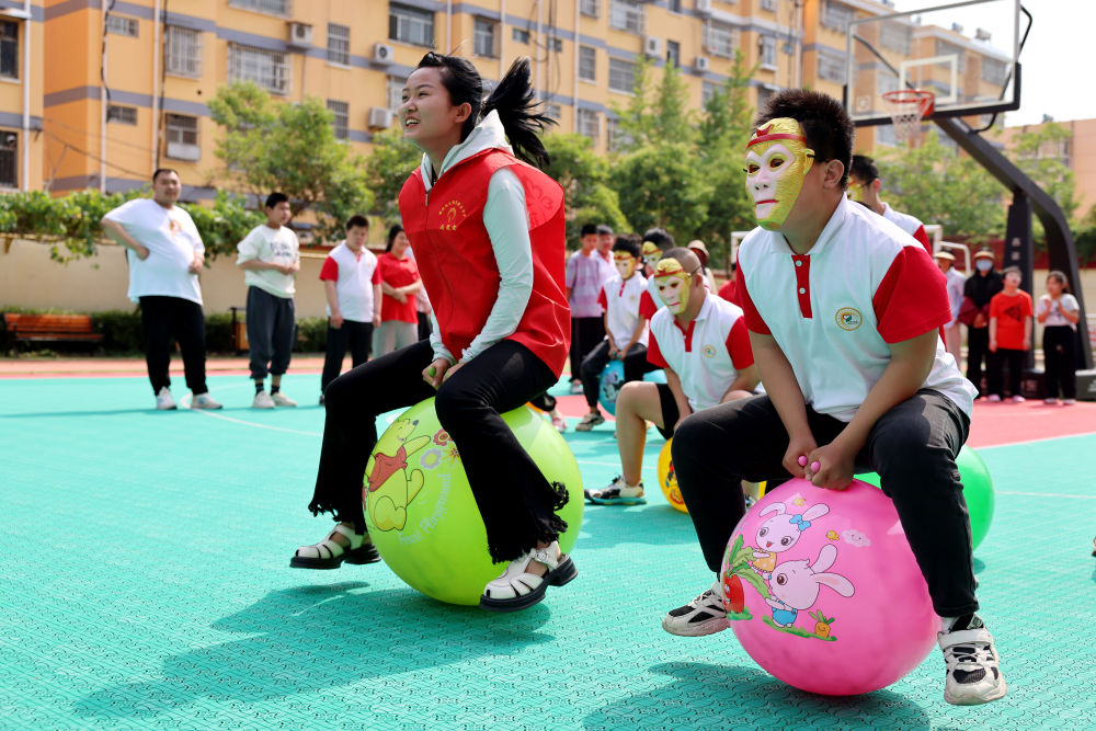 2024年5月17日，在山東省棗莊市市中區特殊教育中心，青年志愿者與智力障礙學生一起做游戲。新華社發（孫中喆攝）